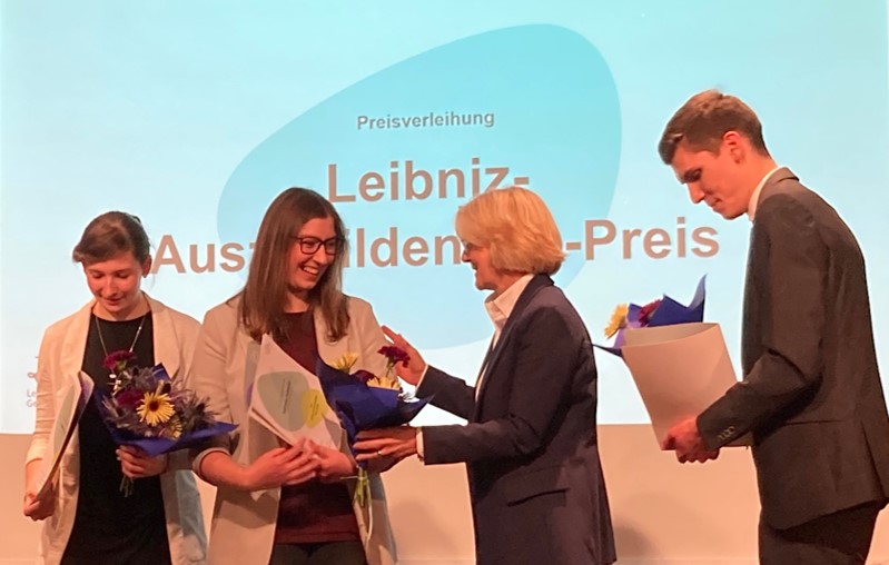 Die Präsidentin der Leibniz-Gemeinschaft, Martina Brockmeier, überreicht Kathrin Schmidt aus dem INM den Leibniz-Auszubildenden-Preis und einen Blumenstrauß